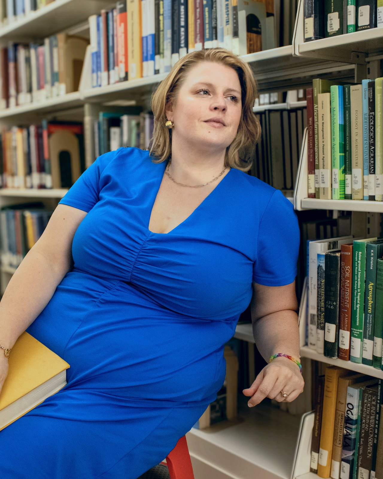 Racheal Pallares holding a book in a library