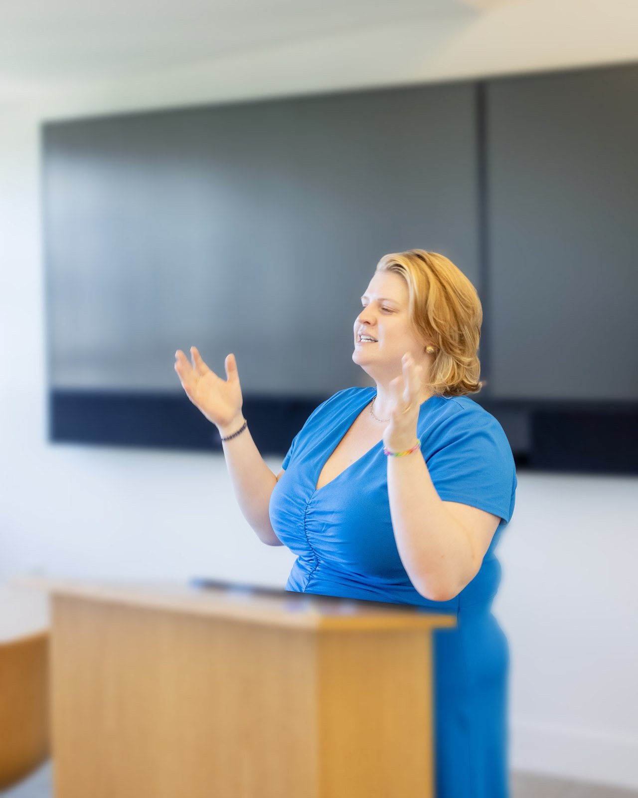 Racheal Pallares speaking at a podium and gesturing toward the audience